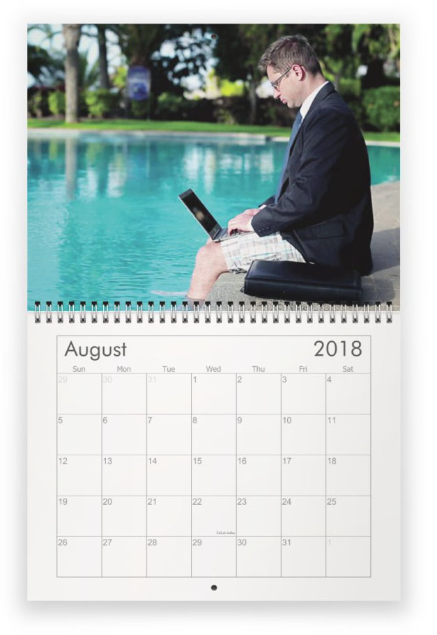 August. Old corporate nerd in suit holding laptop, with feet in pool
